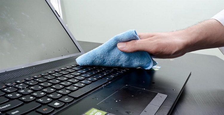 Wiping a drenched laptop with a rag